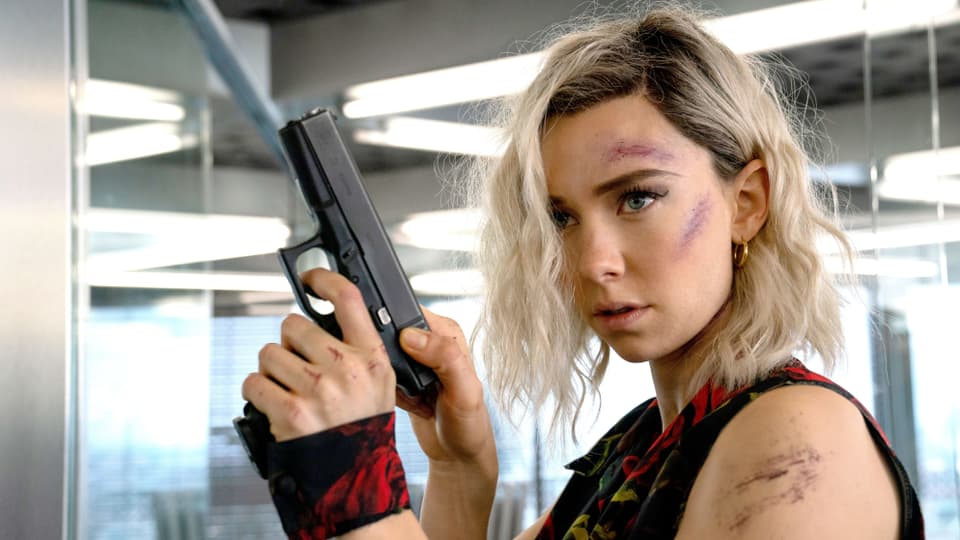 Vanessa Kirby mit einer Pistole in der Hand und Schürfungen im Gesicht. 