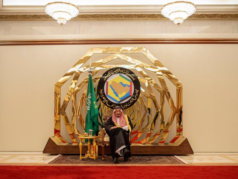 Der saudi arabische König sitzt vor goldenen Ornamenten