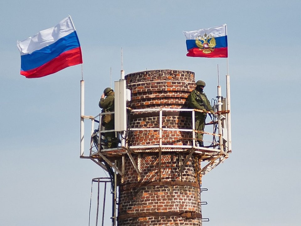 Wachturm mit zwei Soldaten und zwei russischen Flaggen drauf. 