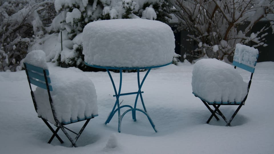 Gartentisch und Stühle mit Schnee bedeckt in einem Garten in Winterthur-Oberseen.