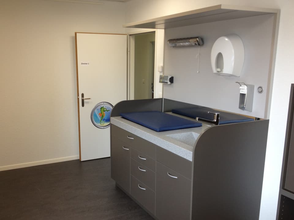 Eines der Praxiszimmer im SwissChildCare Zentrum in Rothrist mit einem Untersuchungstisch für Babys.