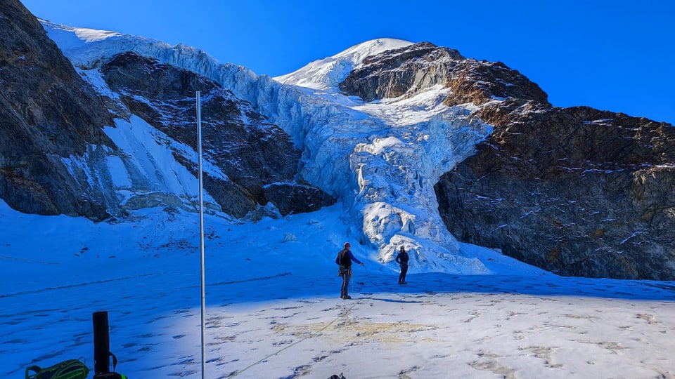 Zwei Männer mit Stangen auf einem Gletscher