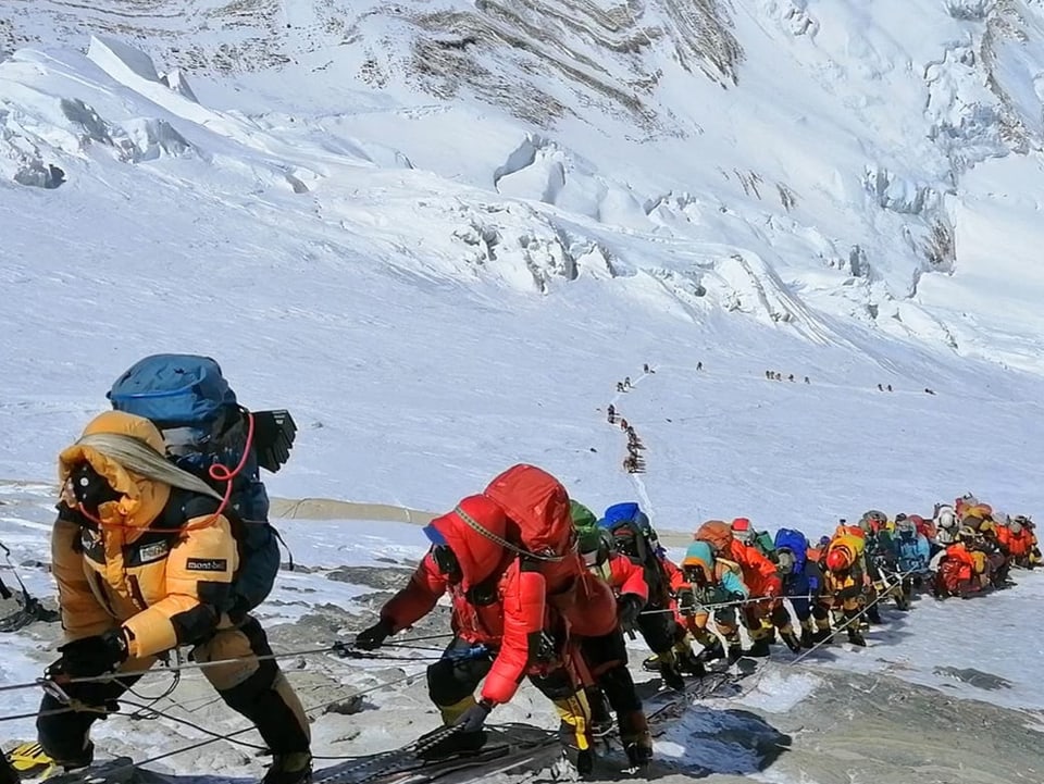 Bergsteiger stehen in einer langen Schlange am Mount Everest.