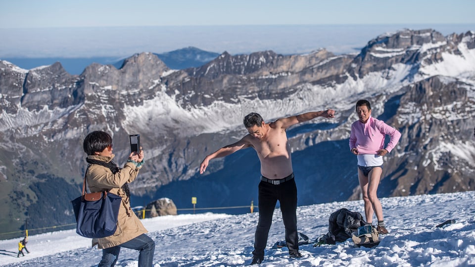 Halbnackte Chinesen stehen im Schnee auf dem Titlis und lassen sich fotografieren.
