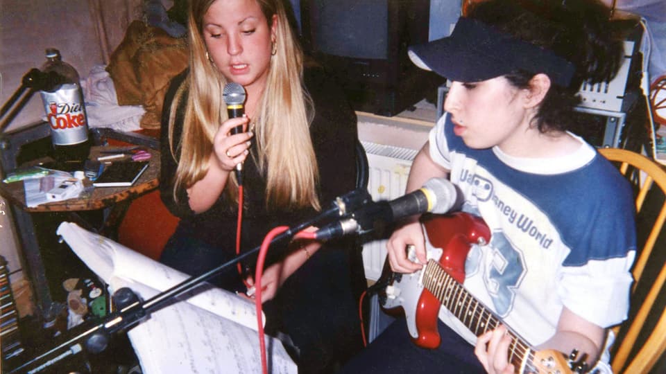 DIe junge Amy Winehouse mit Freundin am Gitarre spielen.