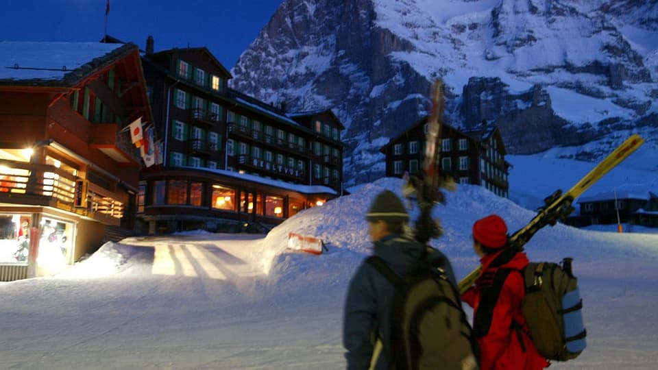 Zwei Skifahrer kehren gegen Abend in ihr Hotel ein
