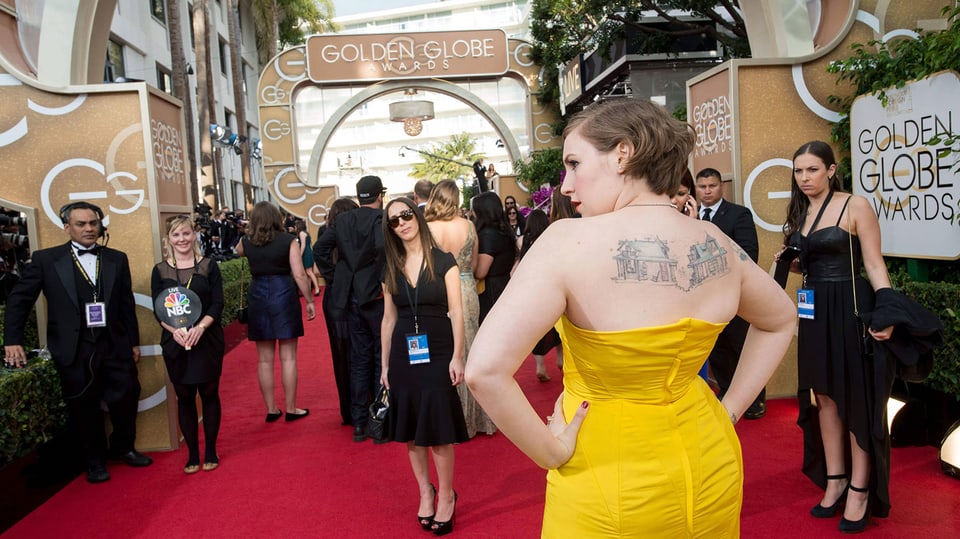 Eine Frau in einem gelben Kleid auf dem roten Teppich der Golden Globes.
