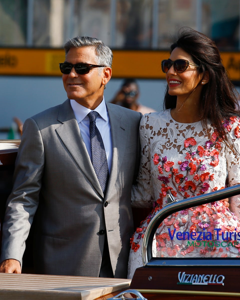 George Clooney und seine Frau posieren auf einem Boot. 