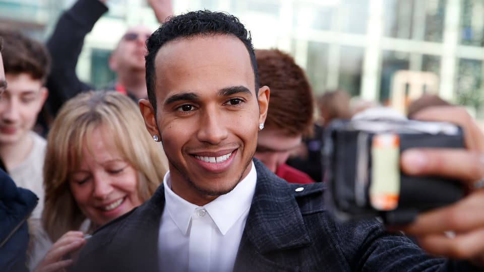 Lewis Hamilton schiesst ein Bild von sich und seinen Fans.