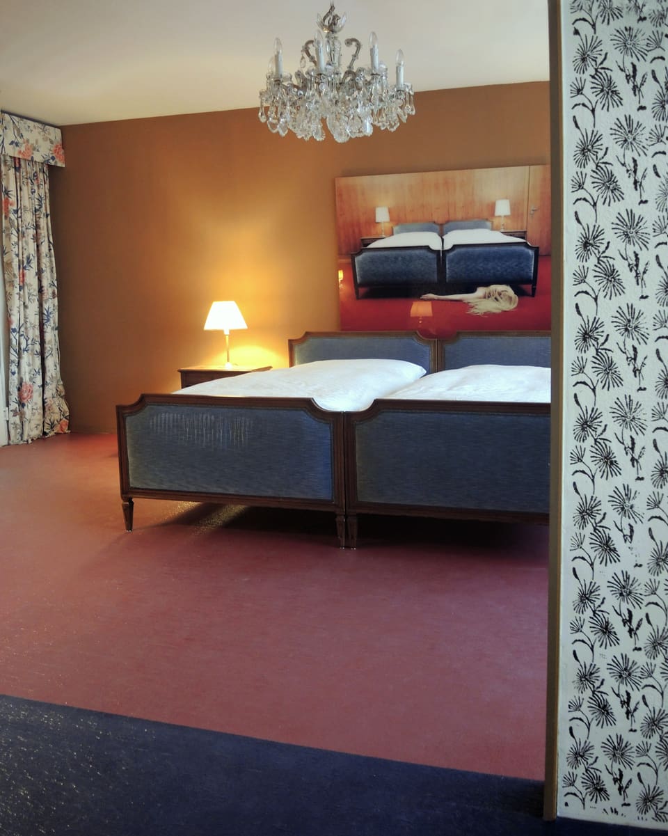 Ein Hotelzimmer mit zwei Betten und Tischlampen.