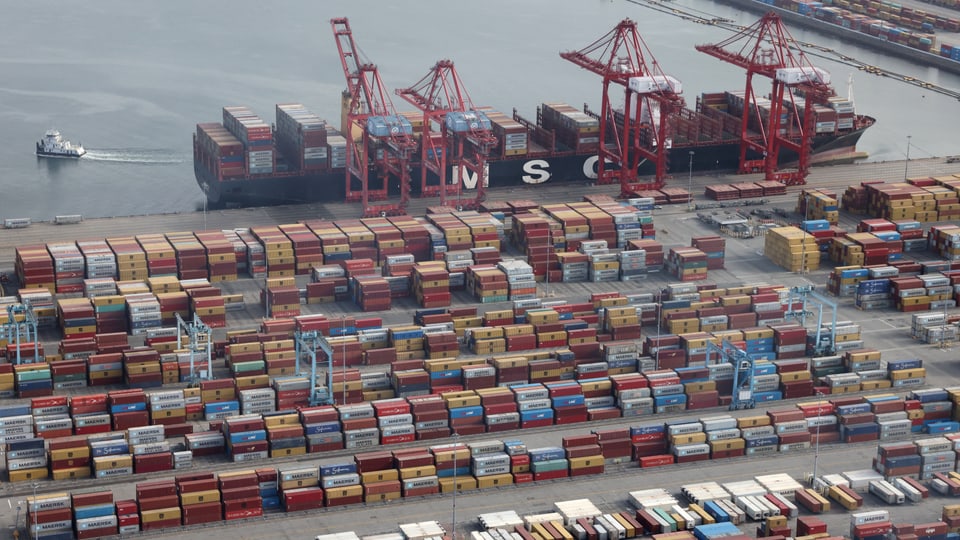 Schiffscontainer werden von einem Schiff an einem Containerterminal im Hafen entladen.