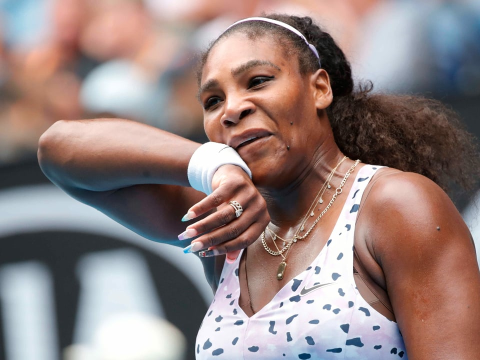 Serena Williams wischt sich mit der rechten Hand übers Gesicht.