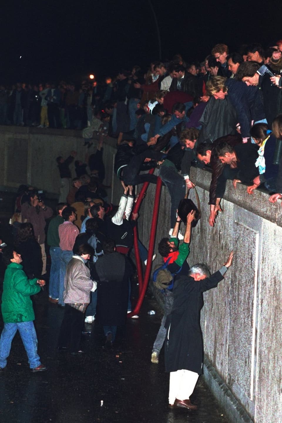 Berliner beklimmen die Mauer.