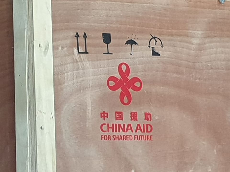 Holzkiste, darauf Aufschrift: «China Aid»