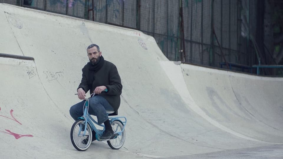 ein Mann fährt auf einem Kindervelo