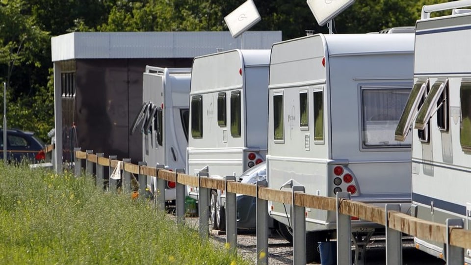 Wohnwagen stehen auf dem Durchgangsplatz für Fahrende im Aarauer Schachen. Im Hintergrund sanitäre Einrichtungen.