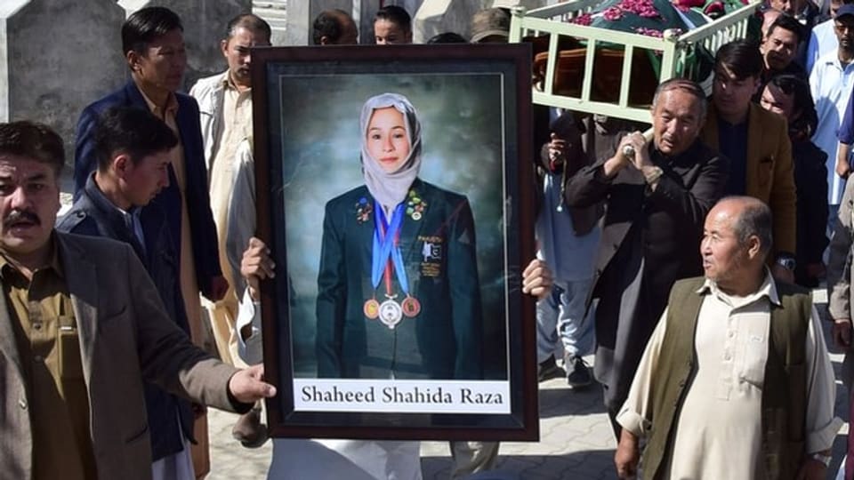 Trauernde umringen ein Bild von Shahida Raza.