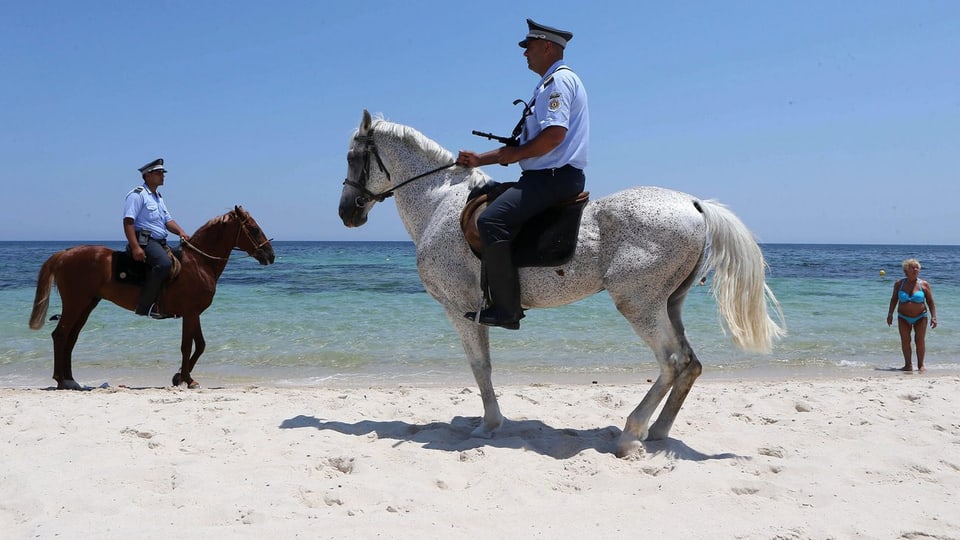 Zwei Polizisten auf Pferden am Strand von Sousse.