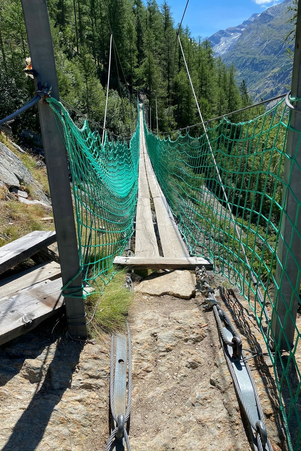 Eine Hängebrücke mit grünem Sicherheitsnetz.