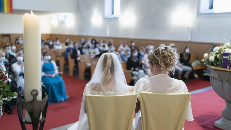 Ein weibliches Paar während der Trauung in einer Kirche.