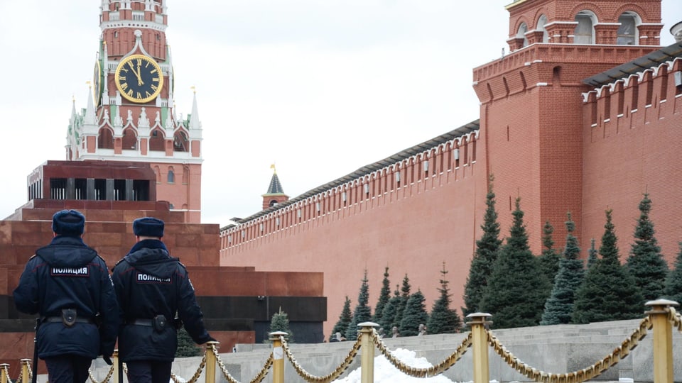 Zwei Polizisten laufen an der Mauer des Moskauer Kremls vorbei.