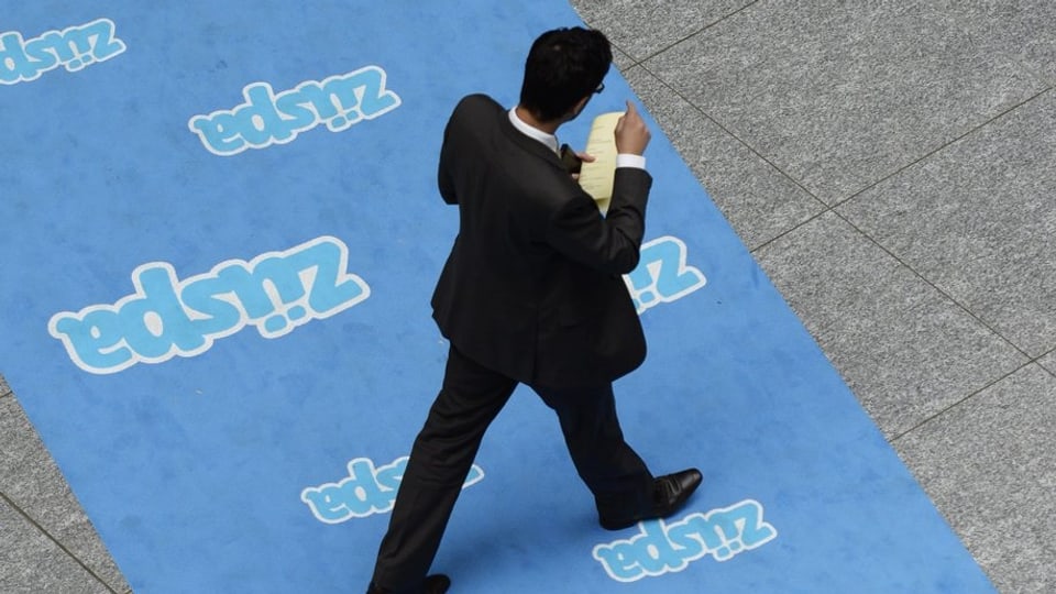 Ein Mann in Anzug läuft über einen Teppich mit der Aufschrift "Züspa", fotografiert von oben.