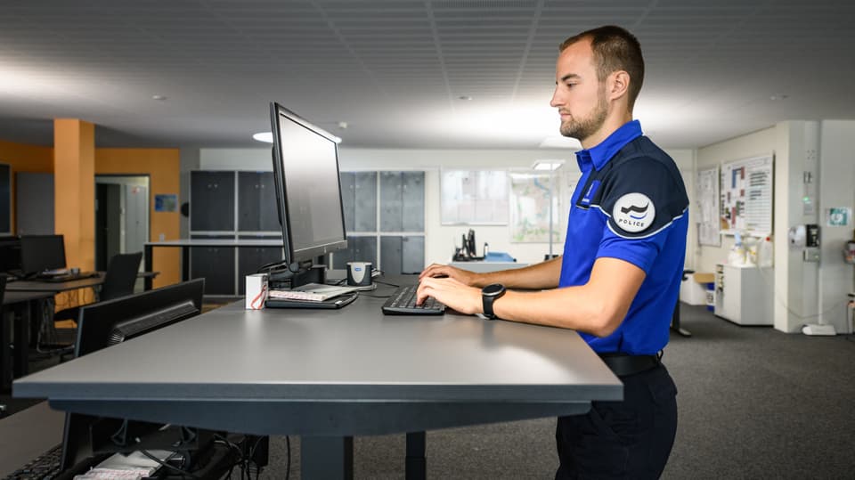 Polizist arbeitet an einem Computer in einem Büro.