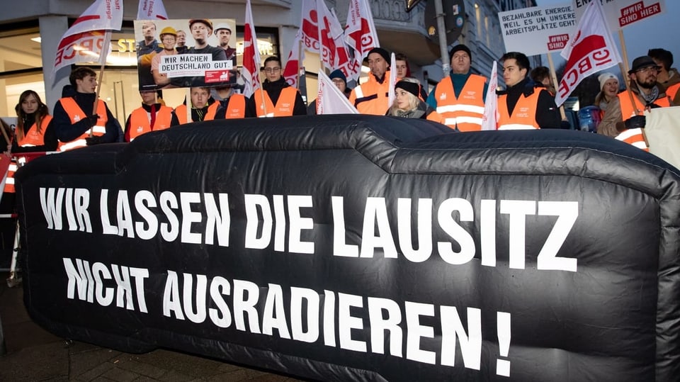 Demonstranten halten ein Plakat hoch: Wir lassen die Lausitz nicht ausradieren.