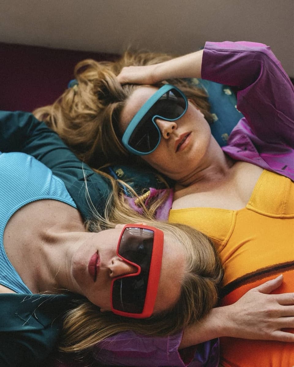 Zwei Frauen mit bunten Sonnenbrillen liegend