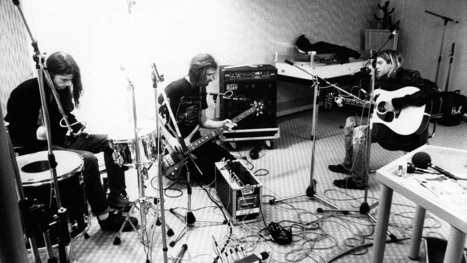 Kurt Cobain und seine Bandkollegen von Nirvana mit Instrumenten im Probraum 
