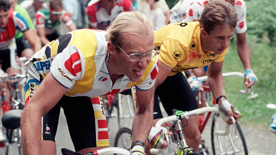Greg LeMond und Laurent Fignon treten nebeneinander in die Pedale.