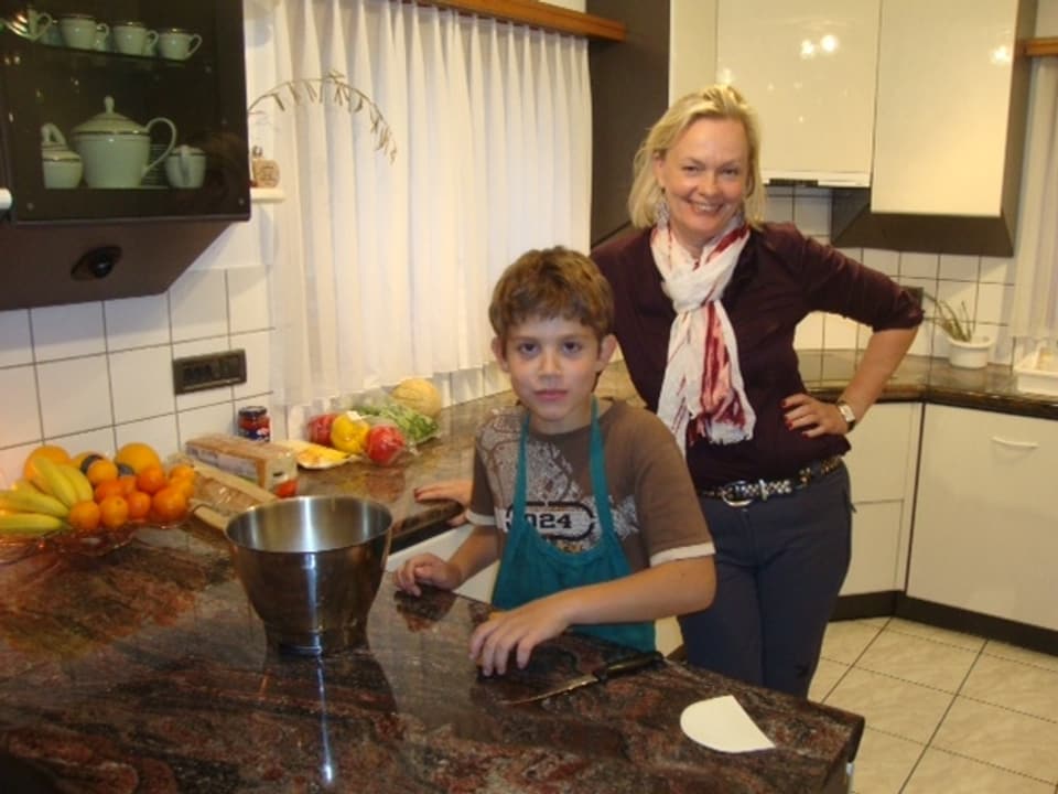 Die blonde Sprachlehrerin Antje Skodock posiert mit Daniele, dem Jüngsten der Familie in der Küche.