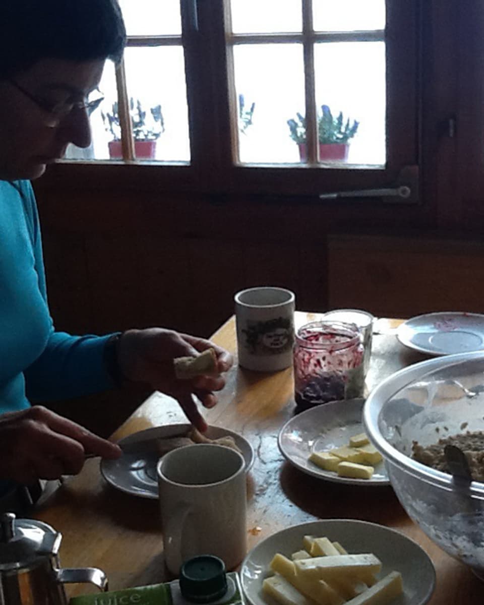 Die Hüttenwartin Monique Kräuchi beim Frühstück auf der Fründenhütte. Es gibt Käse, Birchermüesli, Butter und Kafi.