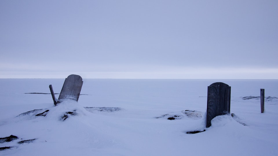 Zwei Grabsteine im Schnee.