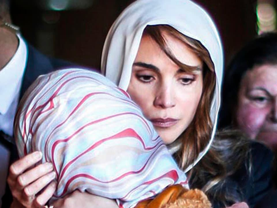 Königin Rania nimt einen Familienangehörige in den Arm