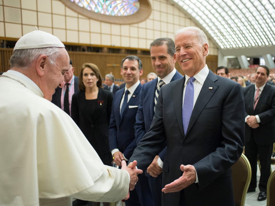Ein Papst und ein Mann begrüssen sich freundlich mit Handschlag.