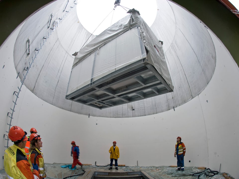 Hier positionieren die Bauarbeiter einen Transformer im Sockel der Windanlage. Es handelt sich um eine im Jahr 2010 gebaute Windanlage des Windparks in Le Peuchapatte (JU).