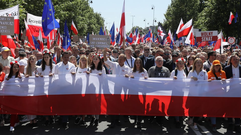 Hunderte Menschen ziehen mit polnischen Flaggen durch Warschau – zuvorderst Donald Tusk