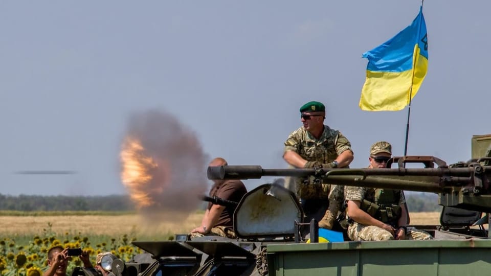Ein Panzer mit Männern drauf, eine ukrainische Fahne weht. Es ist ein Übungsszenario.