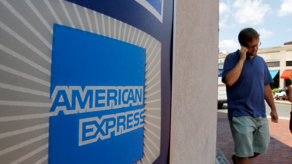 Ein Mann neben dem American-Express-Logo