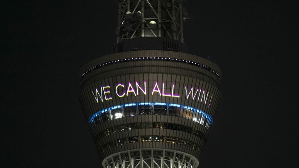 Tokios Turm verbreitet positive Nachrichten: «Together We Can All Win» (engl. für: Zusammen können wir alle gewinnen.)