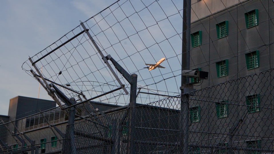 Ein Flugzeug über den Dächern des Gefängnisses am Flughafen Zürich.