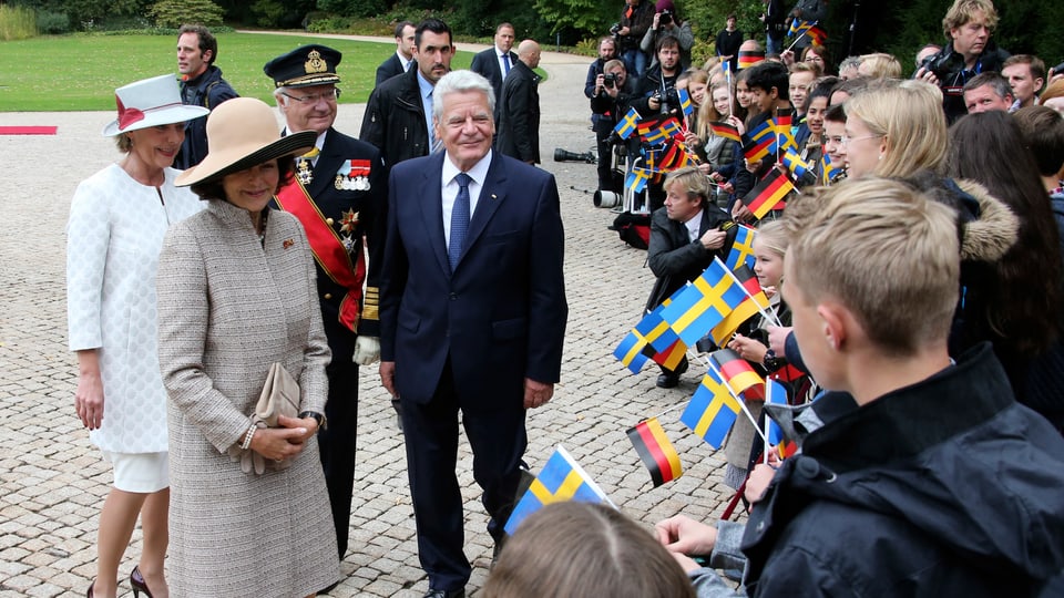 Königin Silvia, König Carl Gustaf und Joachim Gauk werden von Schweden-Fans empfangen.