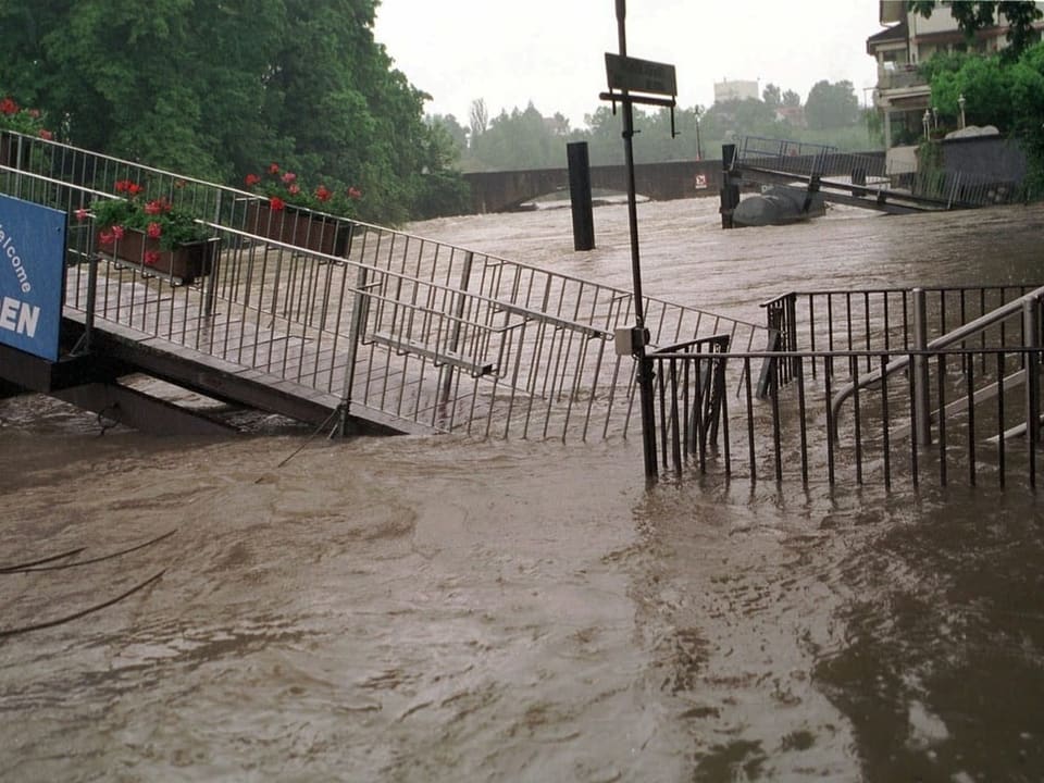 Überschwemmung in Rheinfelden mit hohem Wasserstand und Schild 'Willkommen in Rheinfelden'