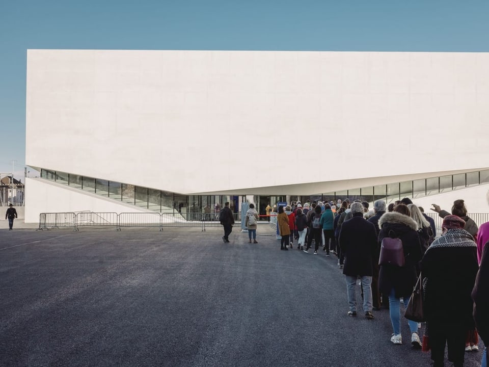 Kolonne von Menschen vor dem Museum.