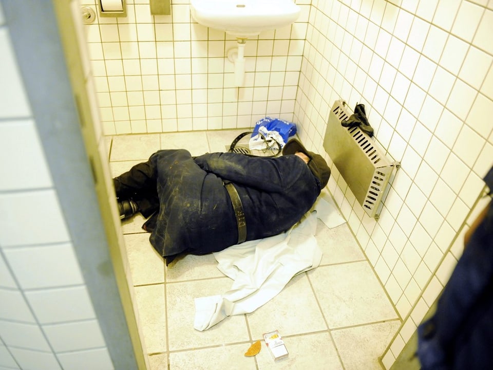 Ein über 75-jähriger Mann schläft auf einer Damen-Toilette in der Zürcher Innenstadt. Auch er will nicht umziehen obwohl es genug Notschlafplätze gibt.