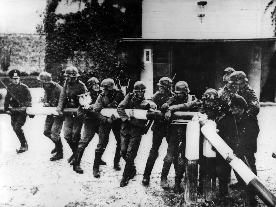 Wehrmachtssoldaten reissen am 1. September 1939 einen Schlagbaum an der deutsch-polnischen Grenze ein.