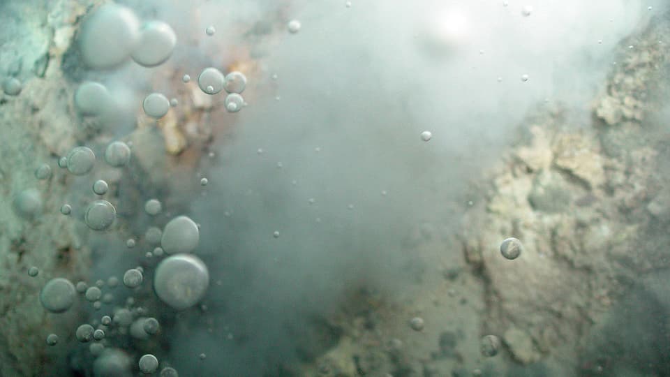 Blasen dringen aus einer heissen Quelle am Grund des Ozeans.