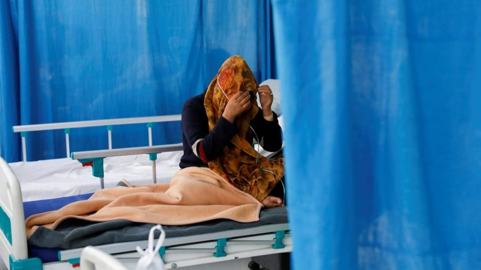 Eine Frau sitzt auf einem Spitalbett in einem Spital in Kabul.