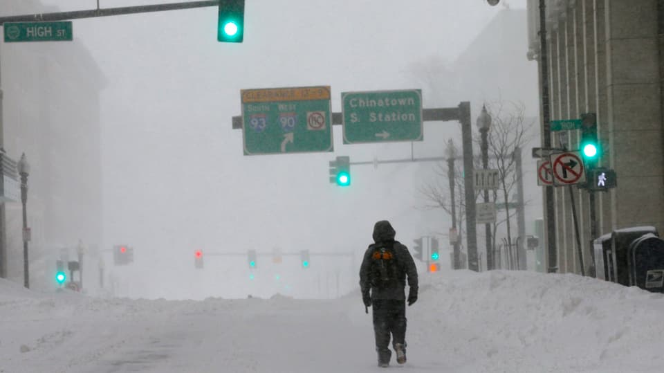 Ein Mann läuft auf schneebedeckter Strasse durch Boston.